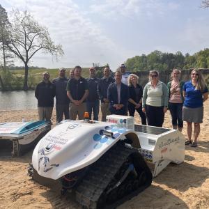 Project partners standing behind the beach cleanup technologies at the media event.