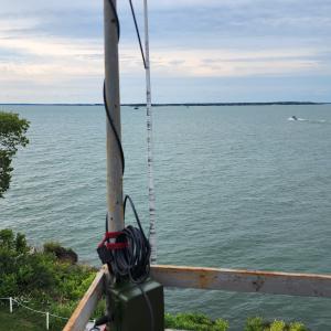 Lake Erie Islands Nature and Wildlife Center research coordinator Dr. Amy Alford places a bat audio detection device on the light tower of the South Bas Island lighthouse. The lighthouse is owned and operated by Ohio Sea Grant's Stone Laboratory.